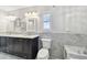 Elegant bathroom featuring marble tiling, dual sinks, storage cabinets, and modern fixtures at 17 Bellevue Dr, Treasure Island, FL 33706