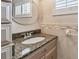 Close up of bathroom vanity featuring granite countertop and round mirror at 17 Bellevue Dr, Treasure Island, FL 33706