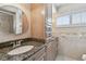 Well-lit bathroom featuring custom cabinets and a large round mirror at 17 Bellevue Dr, Treasure Island, FL 33706