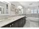Elegant bathroom featuring double vanity, marble countertops, and soaking tub at 17 Bellevue Dr, Treasure Island, FL 33706