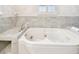 Close up of the luxury tub with marble surround and tile accent wall at 17 Bellevue Dr, Treasure Island, FL 33706