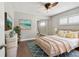 Bright bedroom with a ceiling fan, a queen bed, neutral walls, and wood-look floors at 17 Bellevue Dr, Treasure Island, FL 33706