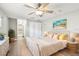 Bright bedroom with a ceiling fan, neutral walls, a queen bed and wood-look floors at 17 Bellevue Dr, Treasure Island, FL 33706