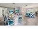Bright dining room with beach decor, two tables, seating for twelve and light hardwood floors at 17 Bellevue Dr, Treasure Island, FL 33706
