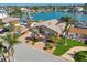 Beautiful waterfront home with brick paver driveway, manicured lawn, and lush tropical landscaping at 17 Bellevue Dr, Treasure Island, FL 33706