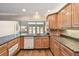 Bright kitchen featuring granite countertops, wood cabinets, and modern appliances overlooking the water at 17 Bellevue Dr, Treasure Island, FL 33706