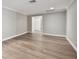 Neutral open room featuring hardwood floors and entry to other rooms at 17 Bellevue Dr, Treasure Island, FL 33706