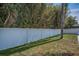 Backyard view featuring a long, pristine white privacy fence and lush green foliage for added privacy at 1710 Hibiscus N Cir, Oldsmar, FL 34677