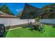 Cozy backyard featuring a fire pit with seating, set on well-manicured artificial turf and enclosed by a white vinyl fence at 1710 Hibiscus N Cir, Oldsmar, FL 34677