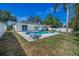 Spacious backyard featuring a pristine pool, outdoor seating, and a well-maintained lawn at 1710 Hibiscus N Cir, Oldsmar, FL 34677