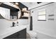 Modern bathroom with black and white contrast, including a round mirror and stylish floating shelves at 1710 Hibiscus N Cir, Oldsmar, FL 34677