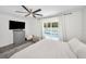 Comfortable bedroom with neutral colors, a large TV, and a sliding glass door that opens to the pool area at 1710 Hibiscus N Cir, Oldsmar, FL 34677