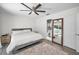 Stylized bedroom with a ceiling fan, neutral rug, and a clear view of the bathroom through a mirror at 1710 Hibiscus N Cir, Oldsmar, FL 34677