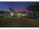 Charming single-Gathering home with a well-maintained lawn, a two-car garage, and mature landscaping under a dusky sky at 1710 Hibiscus N Cir, Oldsmar, FL 34677