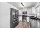 Modern kitchen featuring stainless steel appliances, undermount lighting, and gray toned wood-look flooring at 1710 Hibiscus N Cir, Oldsmar, FL 34677