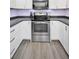Well-lit kitchen features stainless steel range, light wood-look flooring, and modern white cabinets at 1710 Hibiscus N Cir, Oldsmar, FL 34677