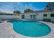 Backyard pool and patio with white fencing and lovely landscaping, offering a great space for entertaining at 1710 Hibiscus N Cir, Oldsmar, FL 34677