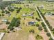 Aerial view of estate home and barn on sprawling lot in established community at 18423 Lithia Towne Rd, Lithia, FL 33547