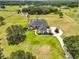 Sprawling estate featuring lush landscaping, a large circular driveway, and a screened-in pool at 18423 Lithia Towne Rd, Lithia, FL 33547