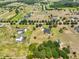 High aerial view of estate home, barn, pool on extensive treed acreage at 18423 Lithia Towne Rd, Lithia, FL 33547