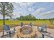 Backyard stone fire pit surrounded by Adirondack chairs with a view of the surrounding property at 18423 Lithia Towne Rd, Lithia, FL 33547