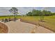 Backyard patio with fire pit and Adirondack chairs surrounded by lush green grass at 18423 Lithia Towne Rd, Lithia, FL 33547