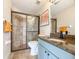 Light and bright bathroom with tiled shower, granite counters, and blue cabinets at 18423 Lithia Towne Rd, Lithia, FL 33547