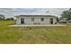 Exterior shot of a home featuring neutral siding, two doors, and windows, complemented by a well-maintained lawn at 18423 Lithia Towne Rd, Lithia, FL 33547