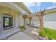 Covered front porch with elegant chandelier, herringbone brick, and cozy pergola seating at 18423 Lithia Towne Rd, Lithia, FL 33547
