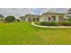 Inviting home with manicured lawn, stone accents, arched windows, and an American flag at 18423 Lithia Towne Rd, Lithia, FL 33547