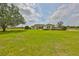 Well-manicured front yard showcases a single-story home with lush landscaping and a long driveway at 18423 Lithia Towne Rd, Lithia, FL 33547