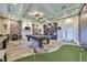 A spacious game room complete with a pool table, putting green, stone wall and bar at 18423 Lithia Towne Rd, Lithia, FL 33547
