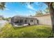 Large, fenced backyard with a screened-in pool, a lush lawn, and beautiful landscaping at 1916 Sandstone Pl, Clearwater, FL 33760
