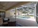 Comfortable covered backyard patio featuring wicker furniture and a view of the screened-in pool and spa at 1916 Sandstone Pl, Clearwater, FL 33760