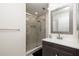 Updated bathroom features a glass-enclosed shower with modern fixtures and a stylish vanity with a decorative mirror at 1916 Sandstone Pl, Clearwater, FL 33760