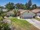 Charming single-story home with a well-manicured lawn, lush landscaping, and an attached two-car garage at 1916 Sandstone Pl, Clearwater, FL 33760