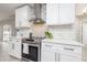 Close-up of the kitchen featuring modern appliances, white cabinets, and stylish backsplash at 1916 Sandstone Pl, Clearwater, FL 33760