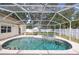 Private screened-in pool area with a relaxing pool, spa, and view of the backyard at 1916 Sandstone Pl, Clearwater, FL 33760