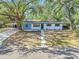 Charming single-story home with blue and white exterior, and a covered parking space at 2003 E Clinton St, Tampa, FL 33610