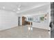 Open-concept living room and kitchen featuring neutral paint, ceiling fan, and bright lighting at 2003 E Clinton St, Tampa, FL 33610