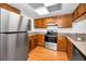 This kitchen features stainless steel appliances, granite countertops and wood cabinets at 209 Woodlake Wynde, Oldsmar, FL 34677