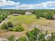 Great aerial view of acreage with home, barn, trees, and fenced area at 21019 Lonesome Acre Rd, Wimauma, FL 33598