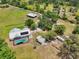 Wide aerial shot highlighting the home, pool, detached garage, and surrounding acreage at 21019 Lonesome Acre Rd, Wimauma, FL 33598