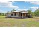 Exterior view of the rustic barn with a metal roof, windows, and fence in the yard at 21019 Lonesome Acre Rd, Wimauma, FL 33598