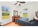 Comfortable bedroom features wood floors, and a large window overlooking a beautiful yard at 21019 Lonesome Acre Rd, Wimauma, FL 33598