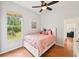 Well-lit bedroom features hardwood floors, large window, and comfortable decor at 21019 Lonesome Acre Rd, Wimauma, FL 33598