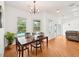 The bright dining area features wood floors, a chandelier, a view of the pool and backyard at 21019 Lonesome Acre Rd, Wimauma, FL 33598