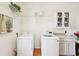 Functional laundry room with washer, dryer, shelving, and cabinet storage at 21019 Lonesome Acre Rd, Wimauma, FL 33598