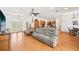 Open-concept living room features wood floors, a comfortable sofa, and leads to the modern kitchen at 21019 Lonesome Acre Rd, Wimauma, FL 33598
