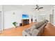 Inviting living room with wood floors, a cozy sofa, entertainment center and lots of natural light at 21019 Lonesome Acre Rd, Wimauma, FL 33598